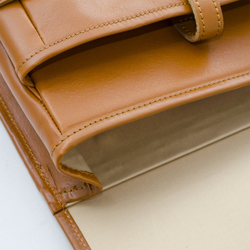 Close-up of a brown leather wallet with visible stitching on a white background