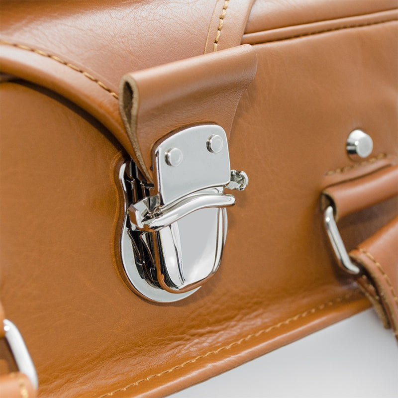 Close-up of a brown leather handbag with a silver clasp on a white background