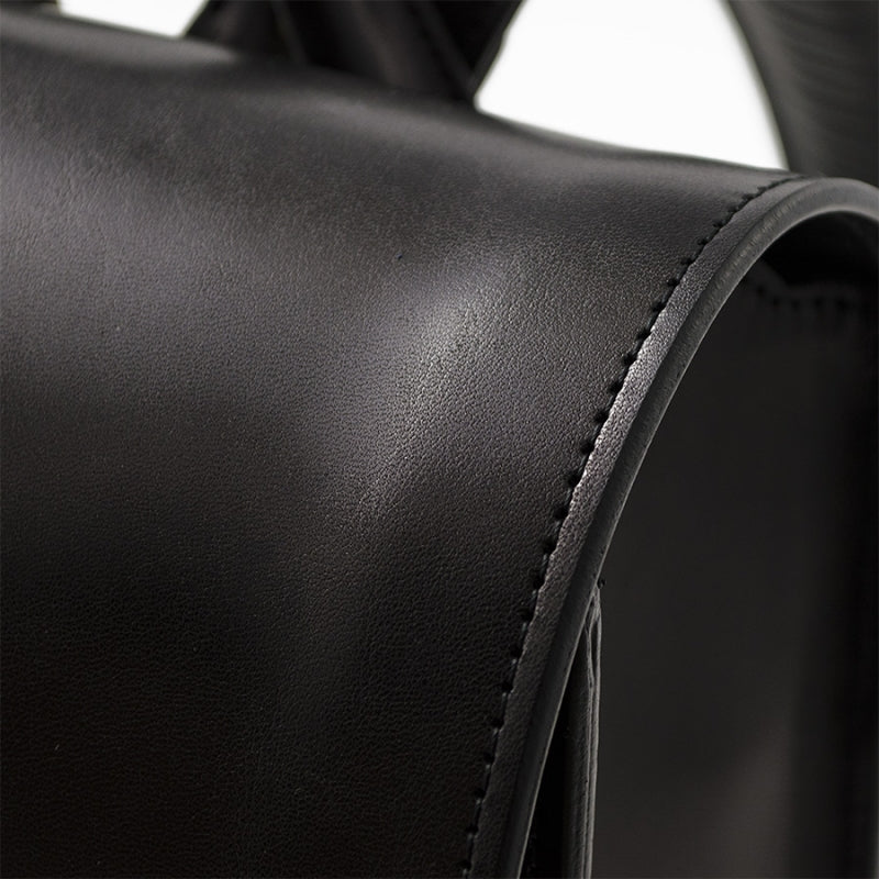 Close-up of a black leather surface with stitching detail