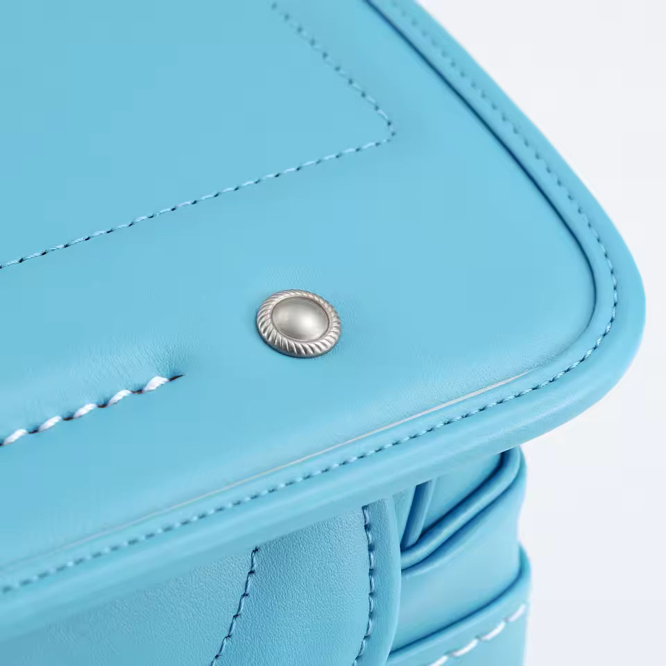 Zen Quality Backpacks- Close-Up of A Blue Leather Product with A Silver Button 