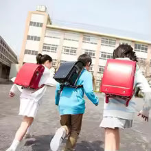 Zen Quality Backpacks Three Students with Red and Black Backpacks Walking in Front of A School Building.